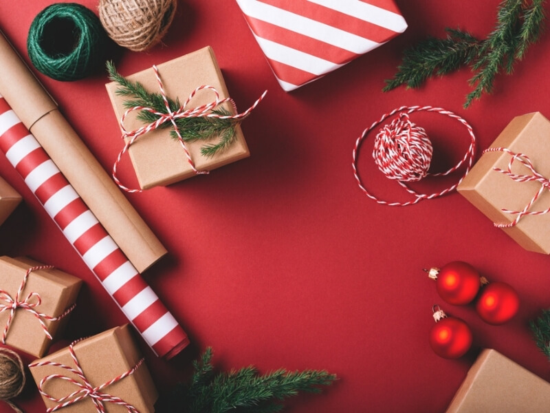 Červeno-biely a recyklovateľný baliaci papier a vianočné darčeky.