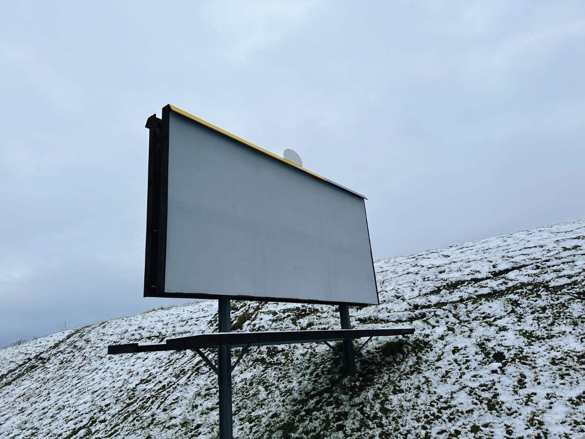 Čistý billboard pri ceste pripravený na novú reklamu.