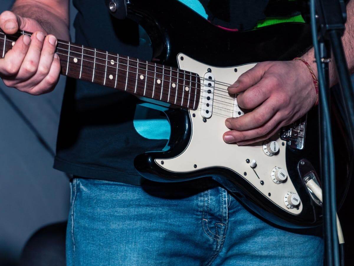 Gitarista hrajúci na gitare ľavou rukou.