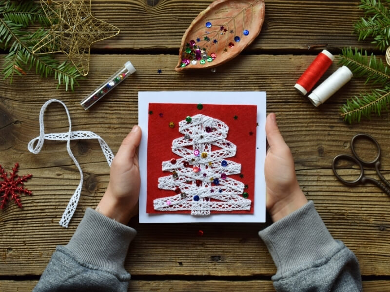 Stromček na vianočnom pozdrave vyrobený z čipkovanej stužky.