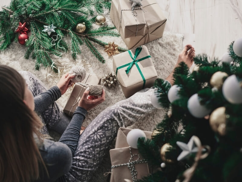 Balenie vianočných darčekov do recyklovaného baliaceho papiera.